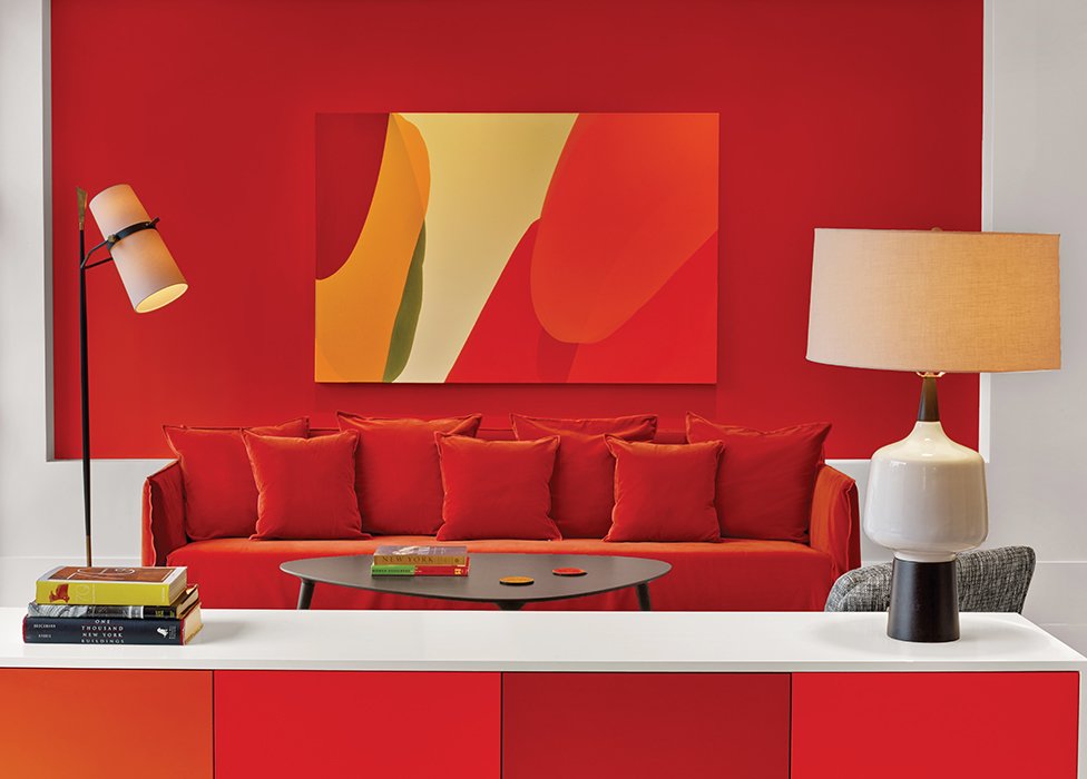 warna merah pada kabinet, sofa, dinding, serta karya seni menciptakan kesan bold / eric striffler